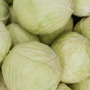 A close-up of fresh, organic cabbages in a pile, perfect for healthy meals.