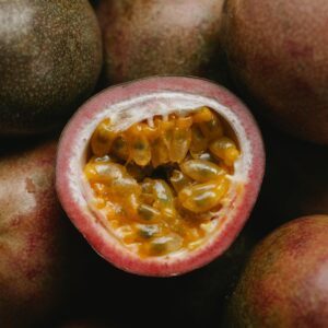A close-up view of a ripe, juicy passion fruit with vibrant yellow pulp and seeds.